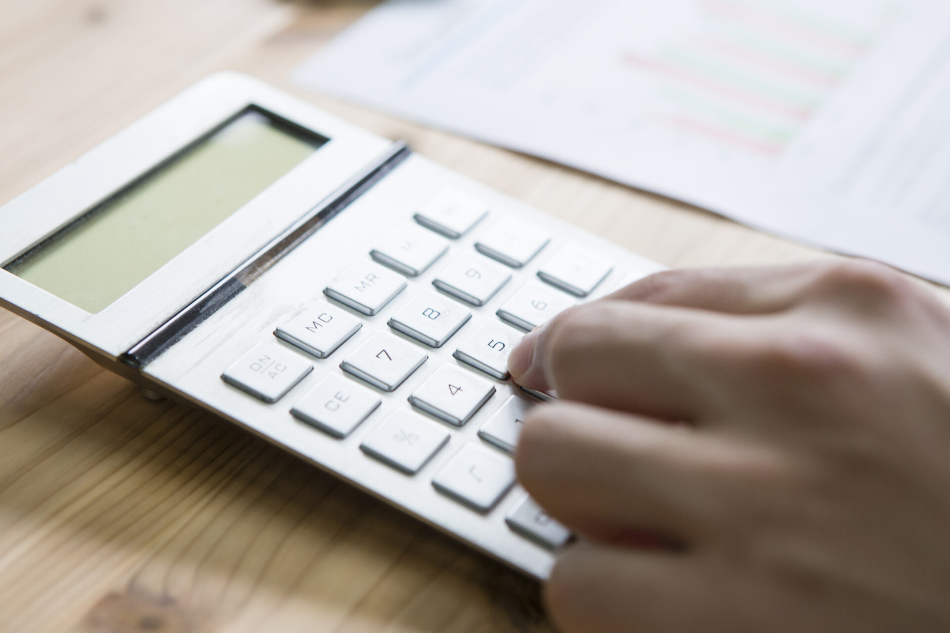 電卓を使って給与やポイントの計算をしている経理部門の従業員