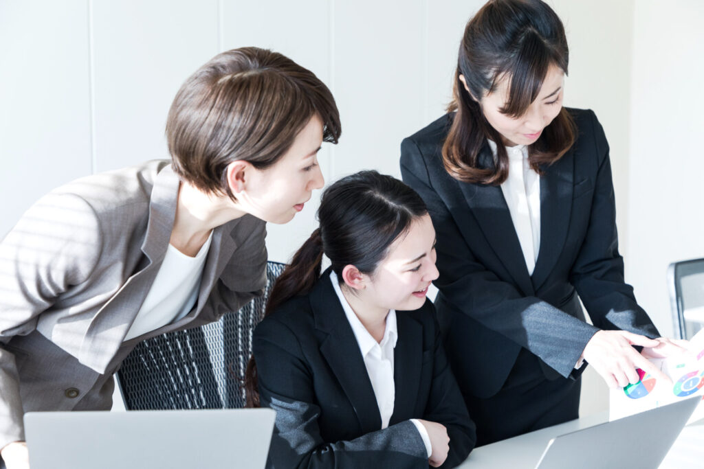 別の部署からインターンで配属された従業員を指導する従業員とその上司