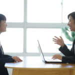 1on1で対話する上司と部下の従業員