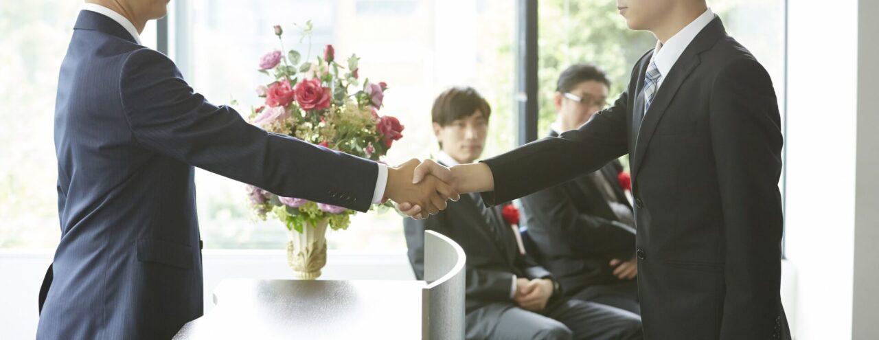 社内表彰イベントで社長から表彰される受賞対象の従業員