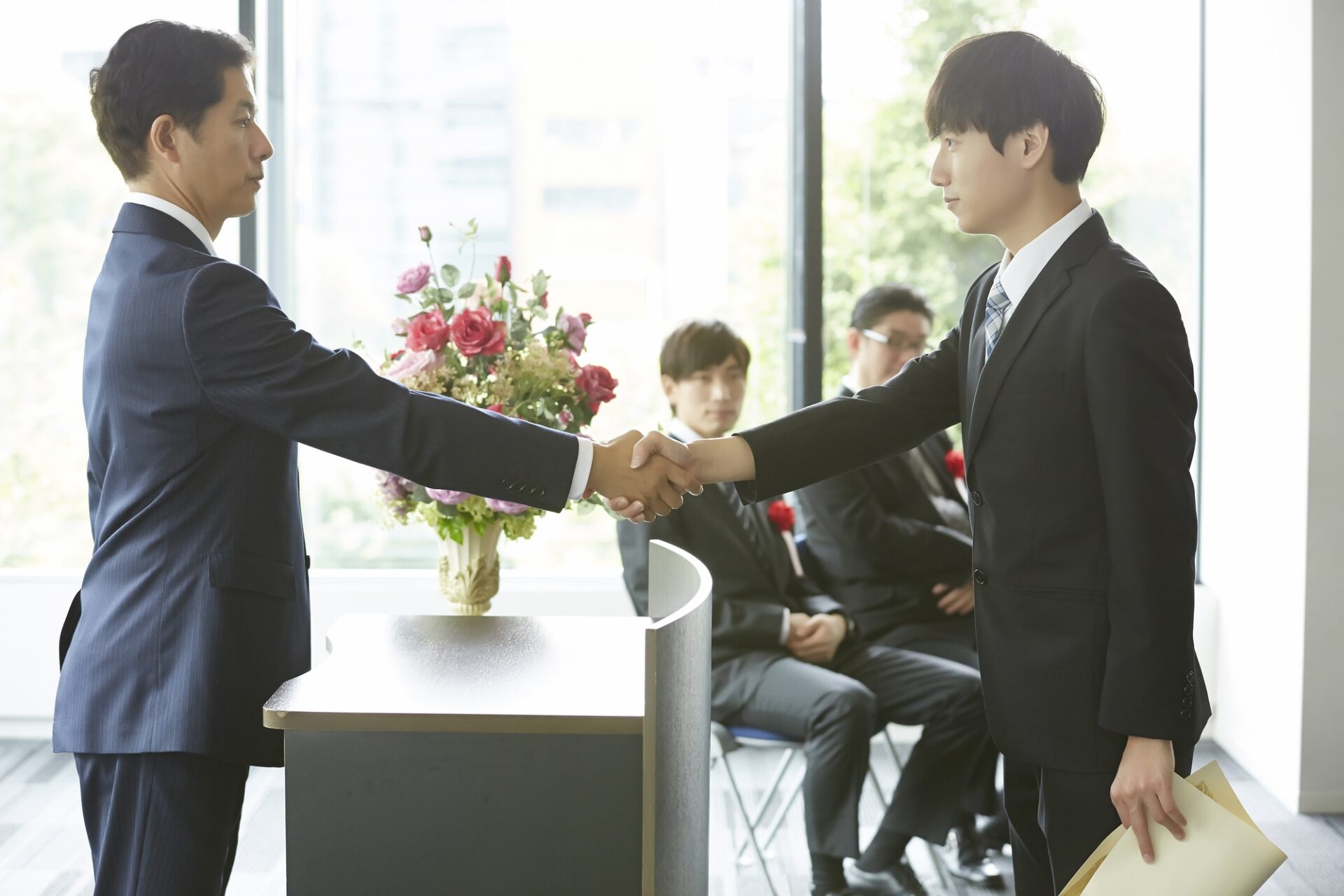 社内表彰イベントで社長から表彰される受賞対象の従業員