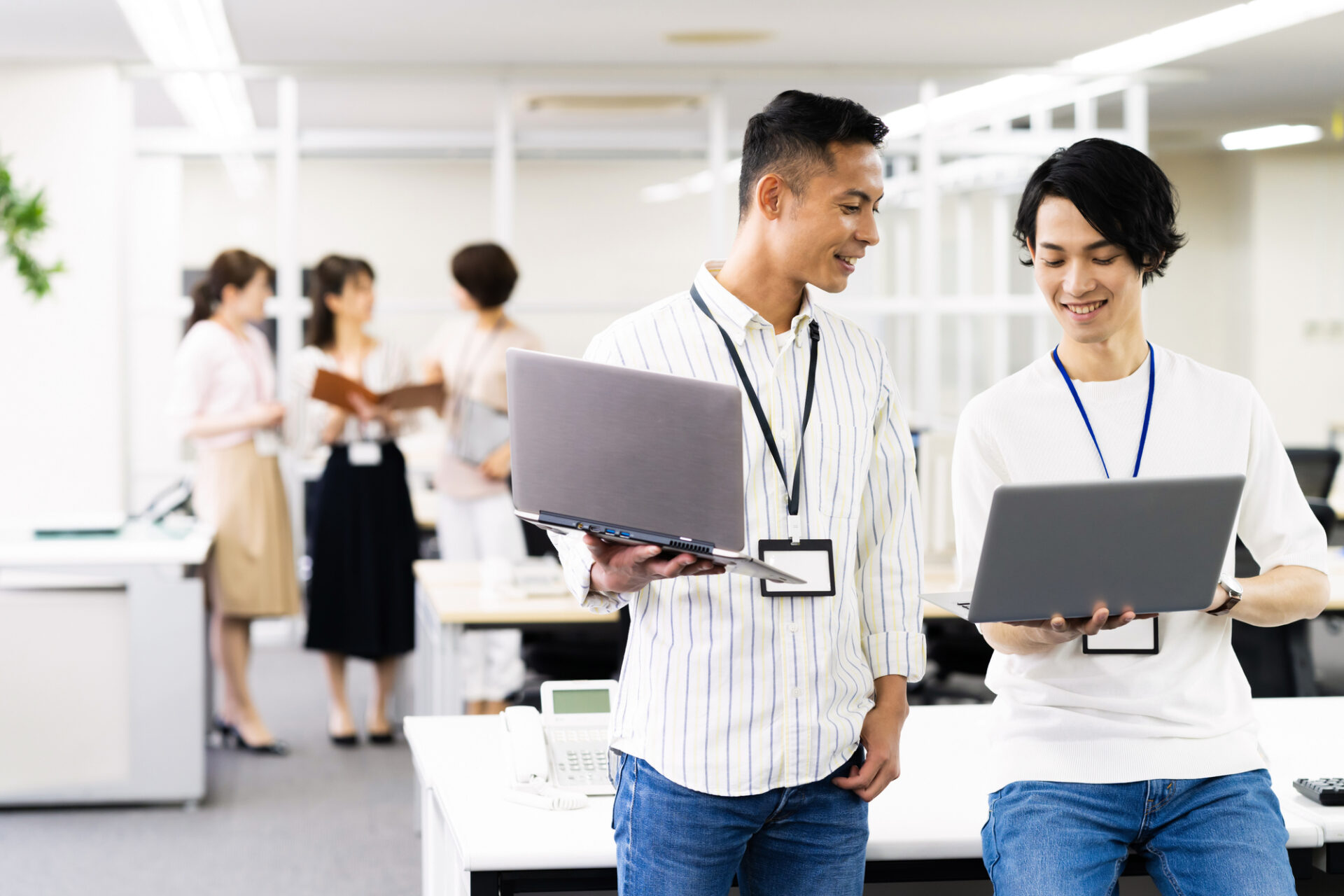 モバイルPCを片手に打ち合わせするデジタル人材の従業員