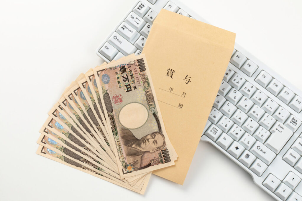 給与明細を見るためのキーボードと現金での賞与のイメージ