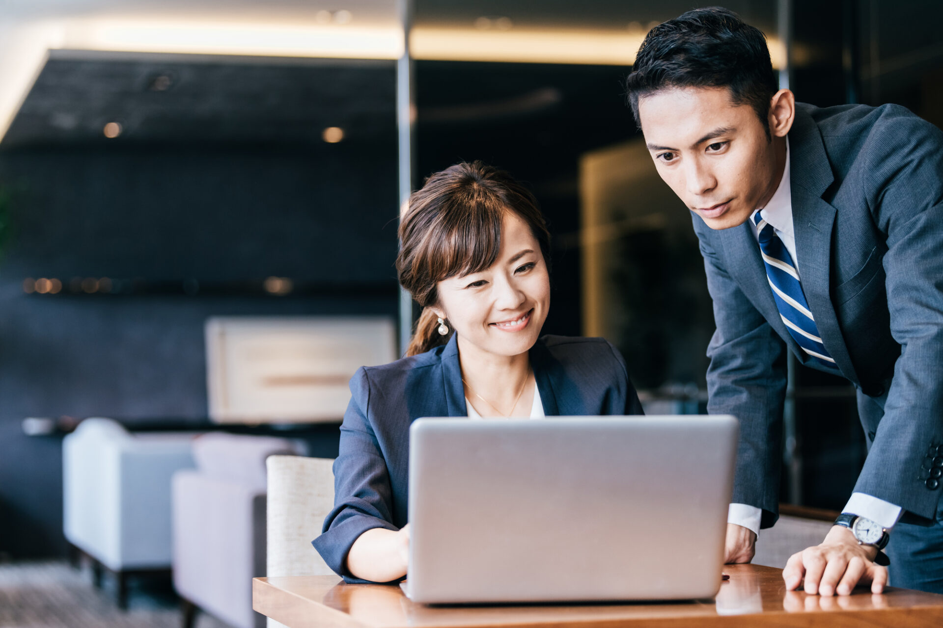 先輩社員が後輩社員に業務を説明しているイメージ